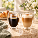 Copos de vidro duplo com café e latte em mesa de café da manhã